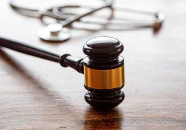 Medical malpractice, personal injury lawyer, healthcare legal aspects. Judge gavel and doctor stethoscope on lawyer office desk. Health and Law concept.